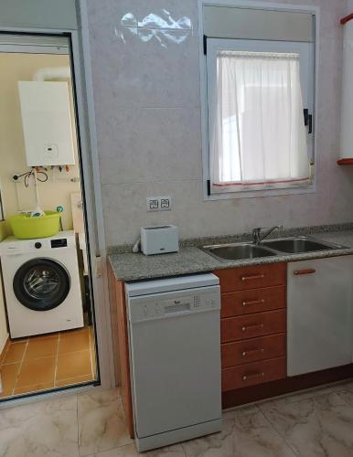 a kitchen with a sink and a washing machine at Apartamentos Querol in Valderrobres