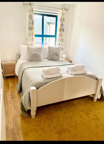 a white bed in a room with a window at Waterfoot Escape in Newcastle