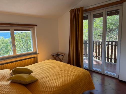 a bedroom with a bed and sliding glass doors at Gold Cave casa vacanze relax nel bosco appartamenti in Pessinetto