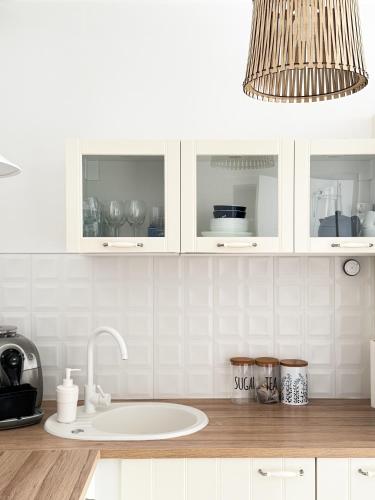 a kitchen counter with a sink and a chandelier at Mountain Szczyrk ApArt Bratków 10A in Szczyrk
