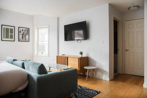ボストンにあるChic Studio Ideal for Nursesのソファとテレビのあるリビングルーム