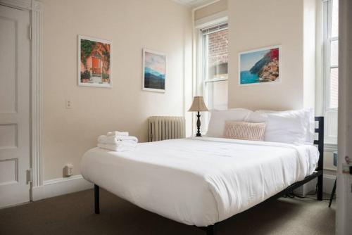 a bedroom with a large bed with white sheets at Charming 1 Bedroom Newbury Street in Boston