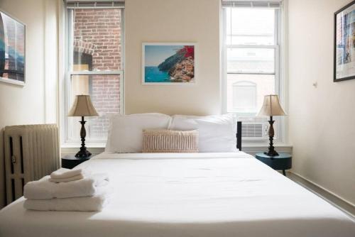 a bedroom with a white bed with towels on it at Charming 1 Bedroom Newbury Street in Boston