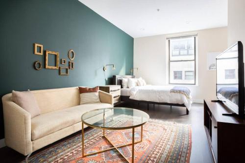 a living room with a couch and a glass table at Prime Boston Fidi L Shaped Studio in Boston