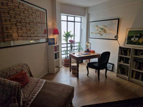 a living room with a table with a chair and a couch at Art Deco Room Condesa Shared Apartment in Mexico City