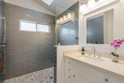 a bathroom with a sink and a mirror at Coastal Dream Heated Pool Near Beach and Disney in Long Beach