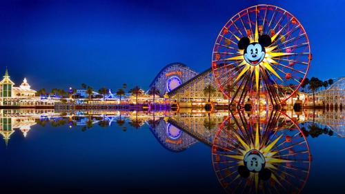 a ferris wheel in front of a city at night at Coastal Dream Heated Pool Near Beach and Disney in Long Beach