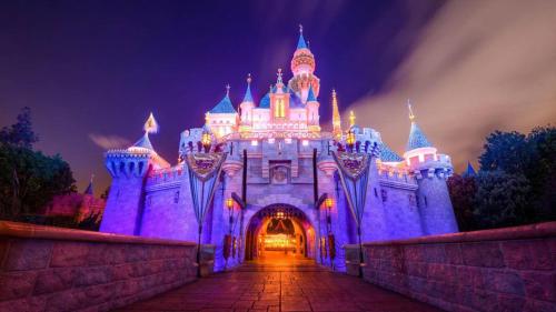a castle lit up in purple at night at Coastal Dream Heated Pool Near Beach and Disney in Long Beach