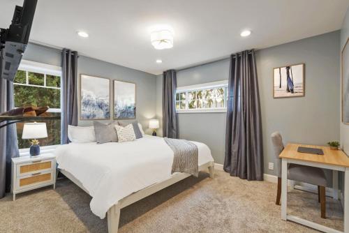 a bedroom with a white bed and two windows at Coastal Dream Heated Pool Near Beach and Disney in Long Beach
