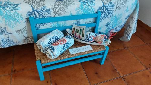 a blue chair with pillows and a plate of books at Villa Damiano in Tarquinia