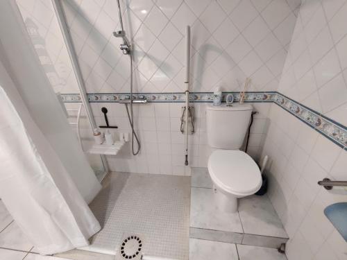 une salle de bain blanche avec toilettes et douche dans l'établissement Vent d'ange maison familiale face à la mer, à Le Cormier