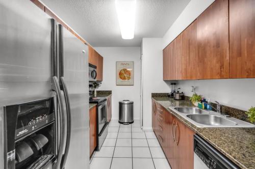 a kitchen with a stainless steel refrigerator and a sink at Enjoy Brickell Living 2 BR Retreat With Free Parking in Miami