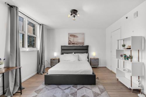 a white bedroom with a bed and two windows at Enjoy Brickell Living 2 BR Retreat With Free Parking in Miami