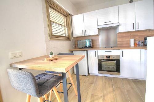 une cuisine avec une table en bois et 2 chaises dans l'établissement Cosy 2 pièces à 5 min à pied de la plage, à Antibes