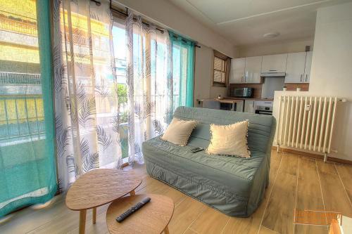 un salon avec un canapé et une table dans l'établissement Cosy 2 pièces à 5 min à pied de la plage, à Antibes