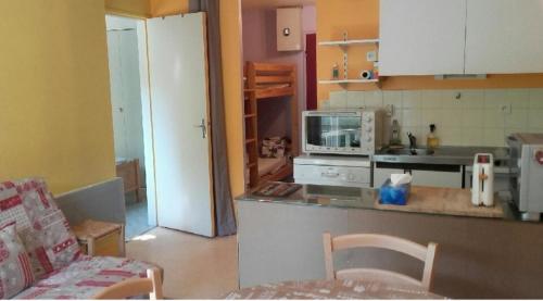 une cuisine avec un comptoir et une cuisine avec un canapé dans l'établissement Appart T2 4 lits 1 chambre 6 personnes, à Laveissière