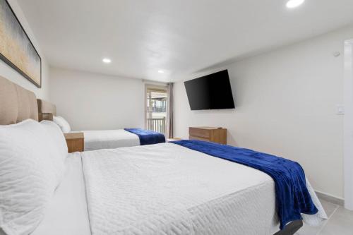 サウス・パドレ・アイランドにあるBahia Mar 160 Sun and Sand Escapeのベッド2台と薄型テレビ付きのベッドルーム