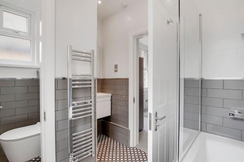 a bathroom with a shower and a toilet and a sink at Amazing One Bed Flat Wimbledon in London