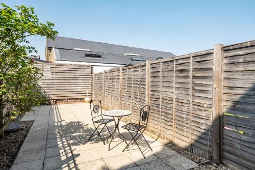 a patio with two chairs and a table in front of a fence at Amazing One Bed Flat Wimbledon in London