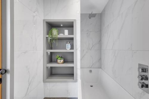 a bathroom with a shelf with a potted plant at Martineau House - North East Escapes in Tynemouth