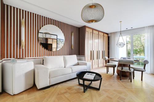 un salon avec un canapé blanc et une table dans l'établissement Super studio 4P avec jardin - Neuilly sur Seine, à Neuilly-sur-Seine