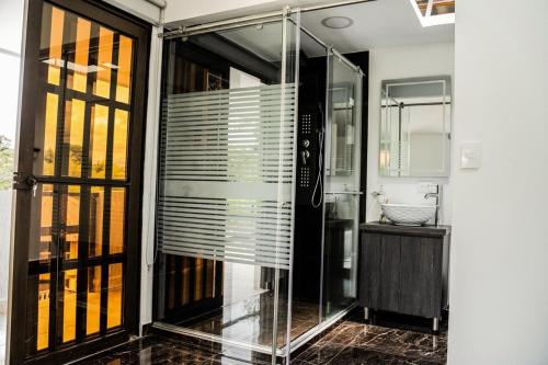 a glass shower in a bathroom with a sink at Casa Finca Román in Montenegro