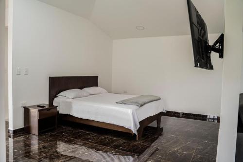 a bedroom with a bed and a tv on a wall at Casa Finca Román in Montenegro