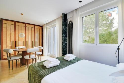 une chambre avec un lit, une table et des chaises dans l'établissement Super studio 4P avec jardin - Neuilly sur Seine, à Neuilly-sur-Seine