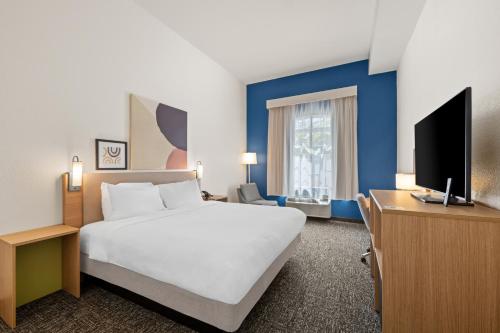 a hotel room with a bed and a flat screen tv at Spark by Hilton Homewood Birmingham in Birmingham
