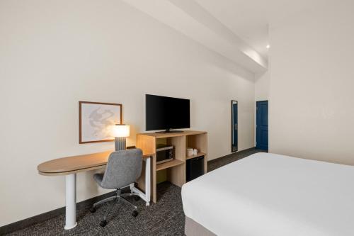 a hotel room with a bed and a desk with a computer at Spark by Hilton Homewood Birmingham in Birmingham