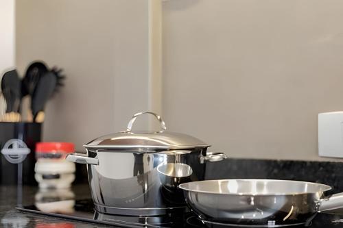 a pot and a bowl on a stove in a kitchen at Apartamentos modernos próximo ao Jardim Botanico e à Rodoviária in Curitiba