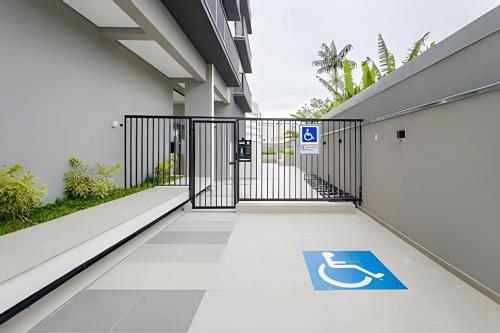 an entrance to a building with a gate with a handicap sign at Apartamentos modernos próximo ao Jardim Botanico e à Rodoviária in Curitiba