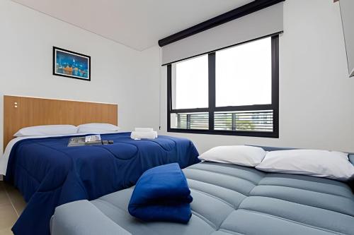 a bedroom with two beds and a couch at Apartamentos modernos próximo ao Jardim Botanico e à Rodoviária in Curitiba