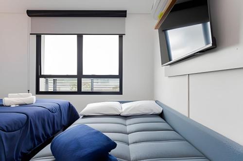 a room with two beds and two windows at Apartamentos modernos próximo ao Jardim Botanico e à Rodoviária in Curitiba