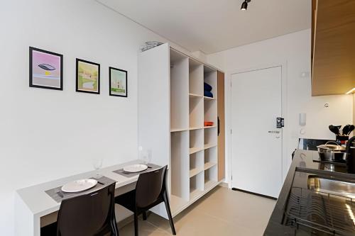 a dining room with a table and chairs in a kitchen at Apartamentos modernos próximo ao Jardim Botanico e à Rodoviária in Curitiba