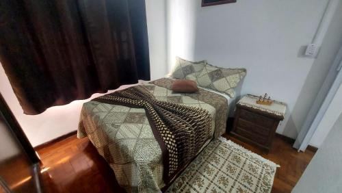 a bedroom with a bed and a night stand at Apartamento frente a praia Santos in Santos