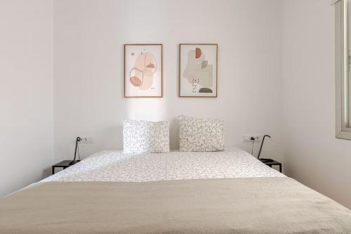 a white bedroom with a large bed with two pillows at Habitación privada en el centro de Bilbao in Bilbao