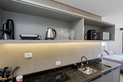 a kitchen with a sink and a counter top at Apartamentos modernos próximo ao Jardim Botanico e à Rodoviária in Curitiba