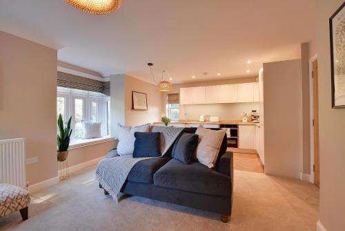 a living room with a couch and a kitchen at Modern flat nestled in the Malvern Hills Worcestershire in Great Malvern