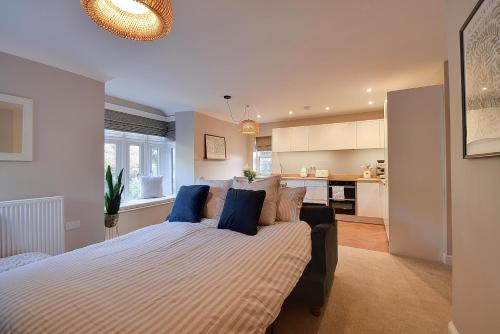 a bedroom with a large bed with blue pillows at Modern flat nestled in the Malvern Hills Worcestershire in Great Malvern