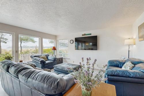 a living room with two couches and a tv at Beach Time Getaway in Lincoln City