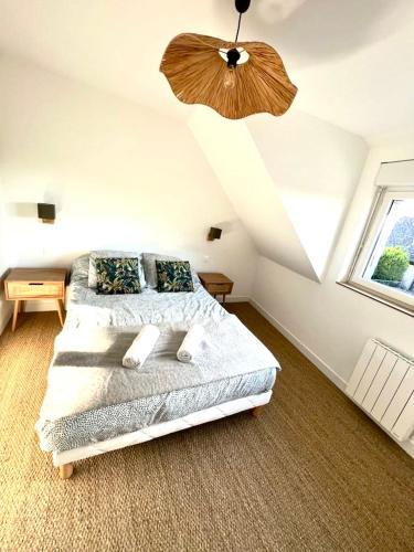 une chambre avec un lit et un ventilateur de plafond dans l'établissement Maison entièrement rénovée Plérin centre, à Plérin