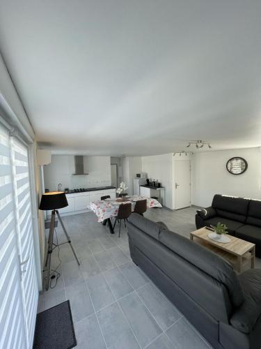 un salon avec un canapé et une table dans l'établissement L'escapade Confort Saint-Quentinoise, à Saint-Quentin