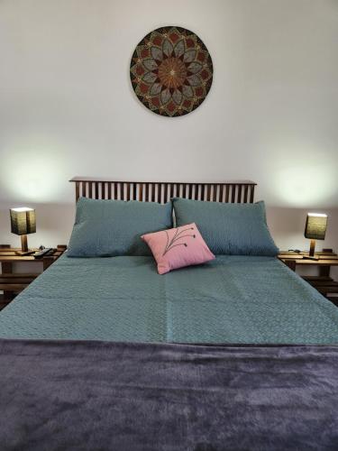 a bedroom with a bed with a pink pillow on it at Casa da Vila in Monte Alegre do Sul