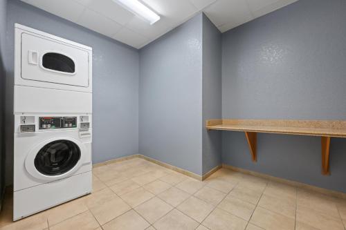 a laundry room with a washing machine and a shelf at Spark by Hilton Homewood Birmingham in Birmingham