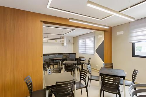 Un comedor vacío con mesas y sillas. en Apartamento garden super moderno próximo ao Jardim Botanico e à Rodoviária - Cama Queen/WIFI/Ar Condicionado, en Curitiba