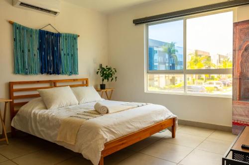 a bedroom with a bed and a large window at Beautiful Apartment in Dream Acapulco Diamante in Acapulco