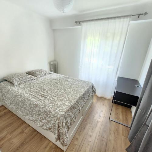 une chambre blanche avec un lit et une fenêtre dans l'établissement Charmant appartement au calme à proximité du Port, de la vieille ville de Nice , de la Promenade des Anglais, à Nice