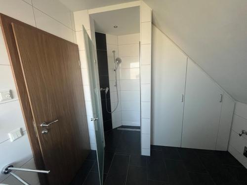 a bathroom with a shower and a glass door at Ferienwohnung direkt am See in Kalkar