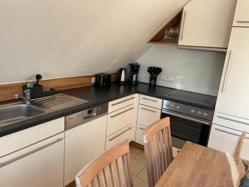 a kitchen with a sink and a table with chairs at Ferienwohnung direkt am See in Kalkar